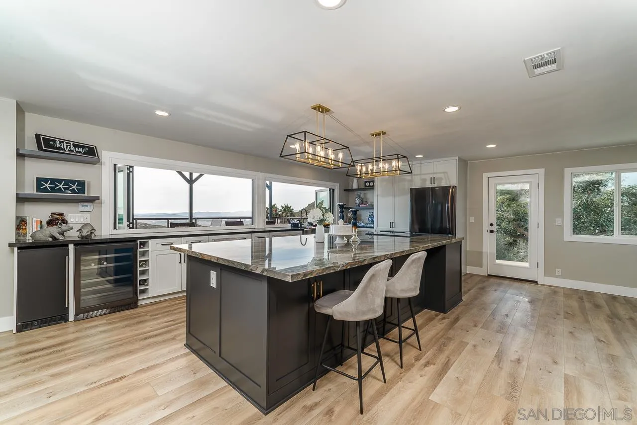 1647 Sleeping Indian Road Fallbrook, CA 92028 - Photo 12 of 48 a kitchen with stainless steel appliances granite countertop a sink a stove and a wooden floors