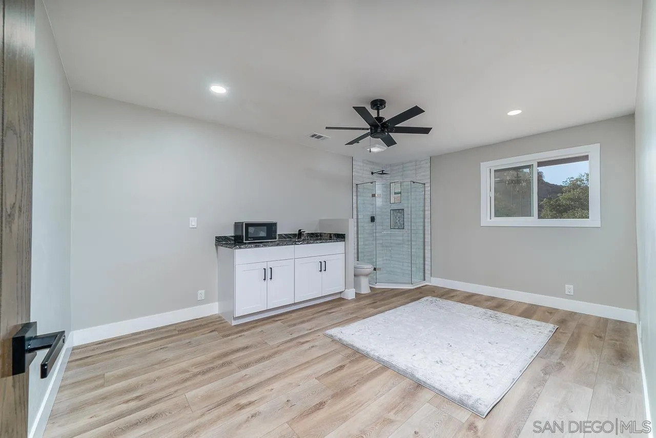 1647 Sleeping Indian Road Fallbrook, CA 92028 - Photo 31 of 48 a kitchen with a refrigerator and white cabinets