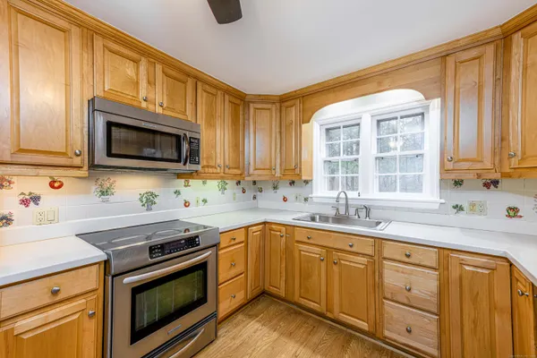a kitchen with stainless steel appliances granite countertop a sink a stove a microwave and cabinets