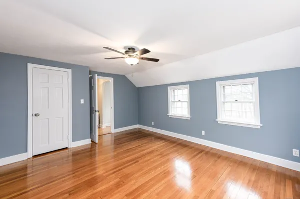 a view of an empty room with a window and wooden floor
