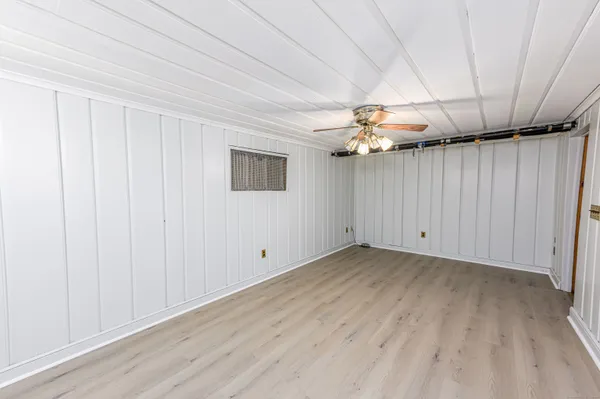 an empty room with wooden floor and fireplace