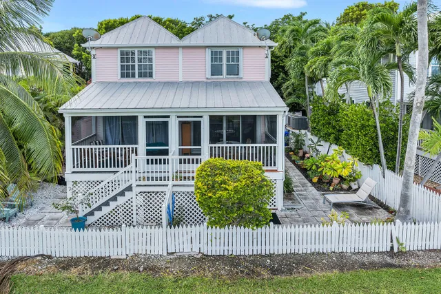 a front view of a house with a garden and plants