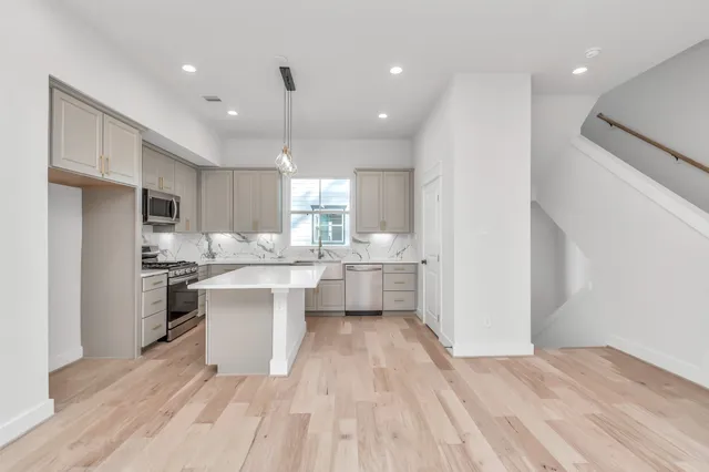 a kitchen with a sink cabinets and wooden floor