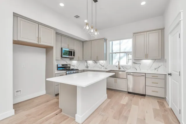 a kitchen with sink a microwave and cabinets