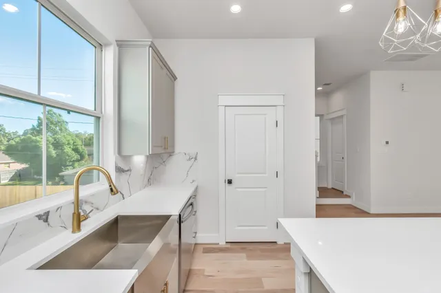 a living room with stainless steel appliances kitchen island granite countertop a sink and a granite counter tops