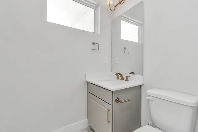 a bathroom with a sink toilet and mirror