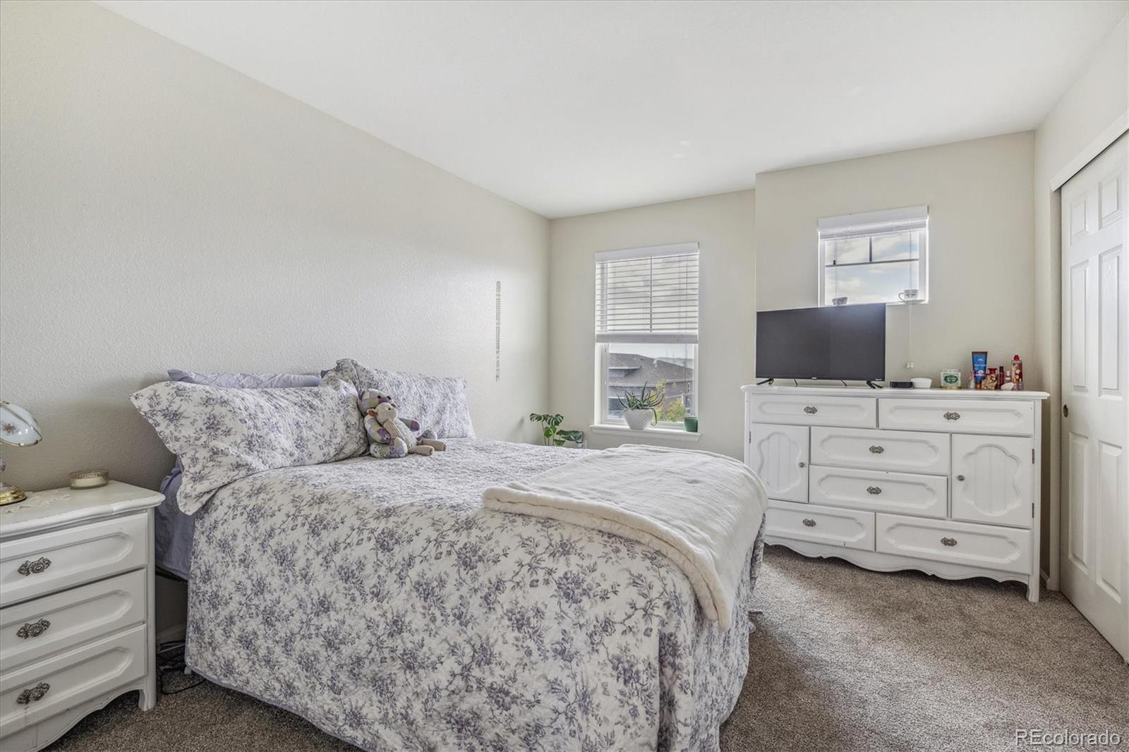 19955 West 93rd Avenue Arvada, CO 80007 - Photo 16 of 33 a bedroom with a bed and flat screen tv