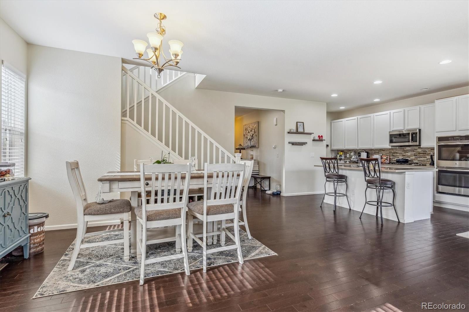 19955 West 93rd Avenue Arvada, CO 80007 - Photo 7 of 33 a dining room with furniture entryway and wooden floor