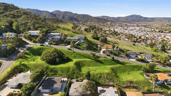 an aerial view of residential house with parking and mountains