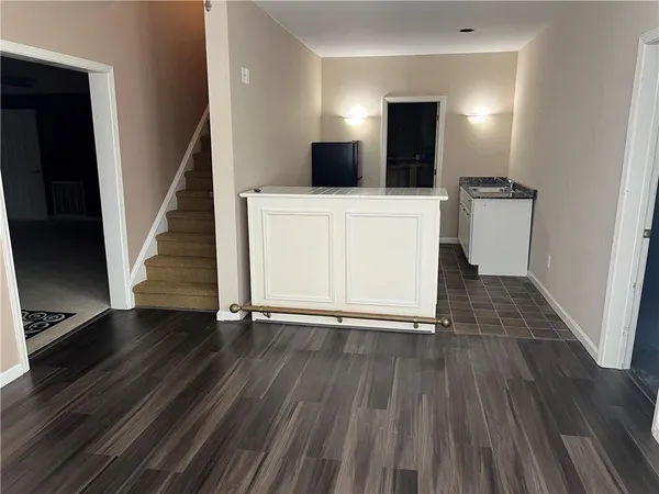 a view of a kitchen with wooden floor and electronic appliances