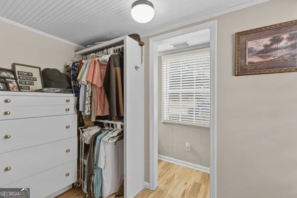 a view of walk in closet with clothes and shoes