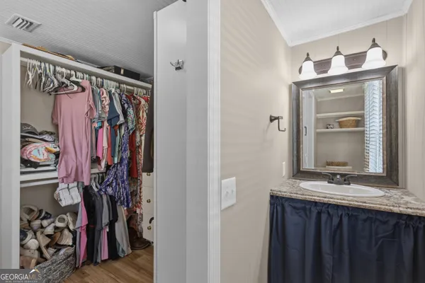 a view of walk in closet with clothes