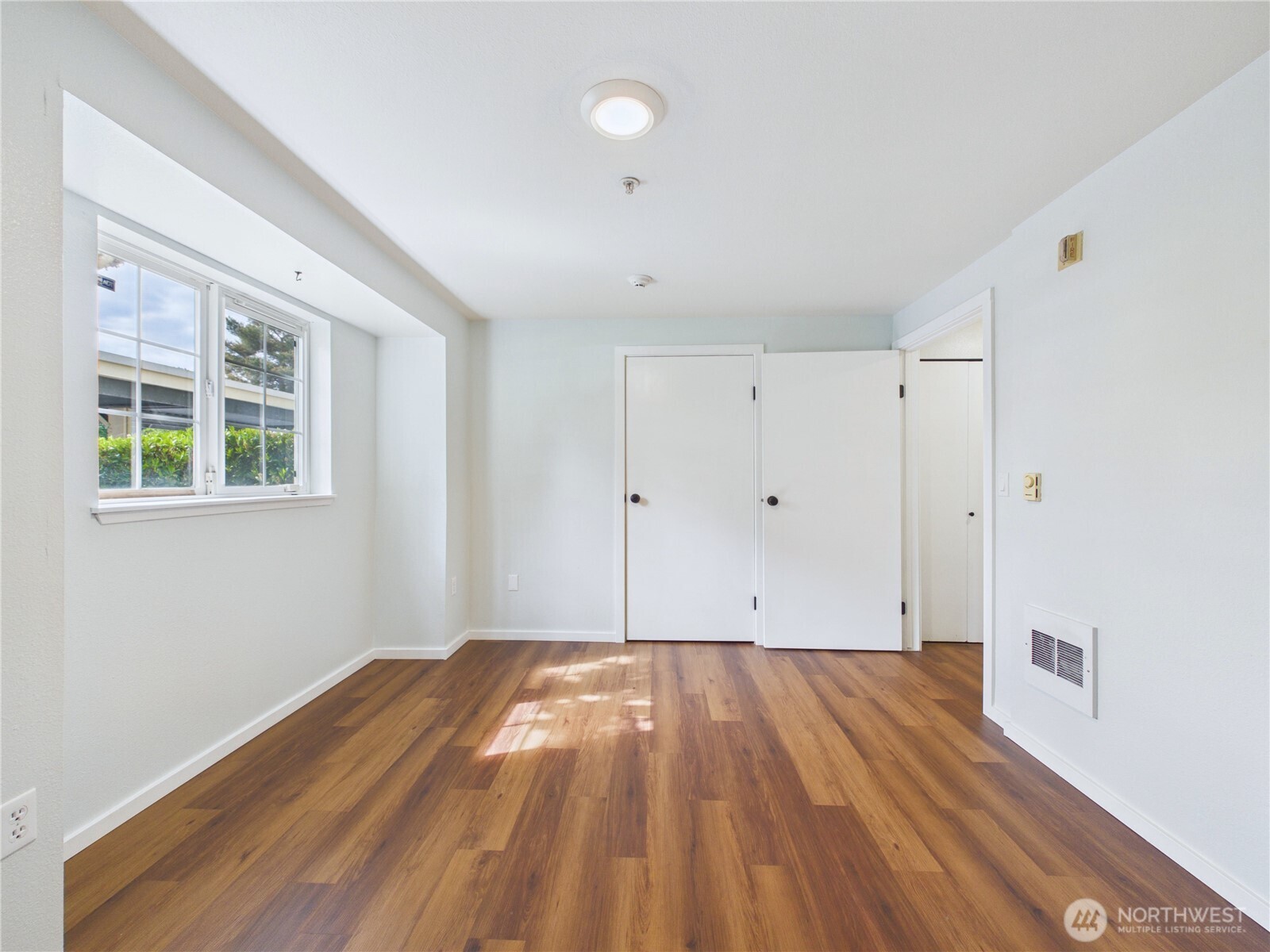 11002 Southeast Petrovitsky Road, Unit I102 Renton, WA 98055 - Photo 16 of 24 a view of room with wooden floor and white walls