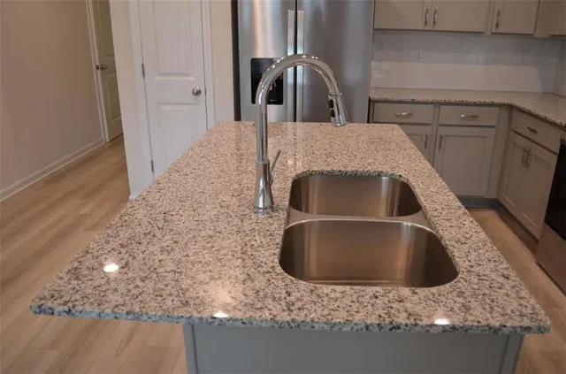 a kitchen with kitchen island granite countertop a sink and granite counter tops
