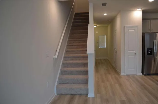 a view of a hallway with wooden floor and staircase
