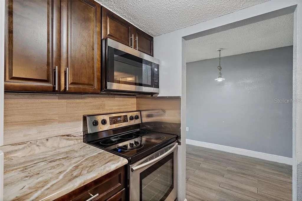 379 47th Avenue North, Unit 103 St. Petersburg, FL 33703 - Photo 14 of 24 a kitchen with a stove microwave and sink