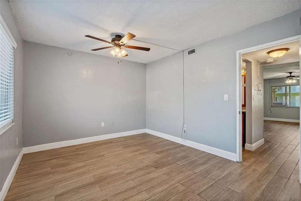 379 47th Avenue North, Unit 103 St. Petersburg, FL 33703 - Photo 22 of 24 a view of an empty room with closet and a chandelier fan