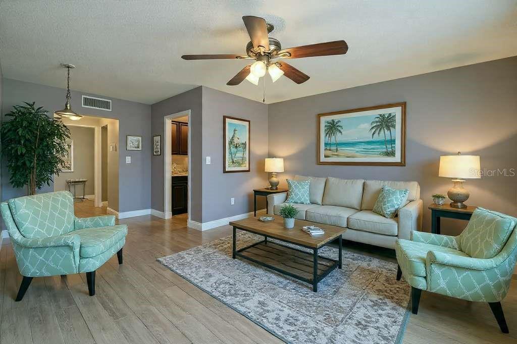 379 47th Avenue North, Unit 103 St. Petersburg, FL 33703 - Photo 5 of 24 a living room with furniture a ceiling fan and a rug