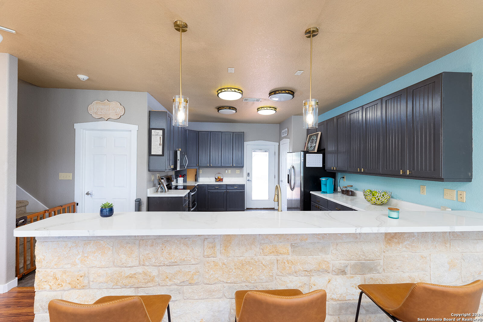 140 Twin Springs Road North Kerrville, TX 78028 - Photo 14 of 47 a kitchen with stainless steel appliances kitchen island granite countertop a sink cabinets and wooden floor