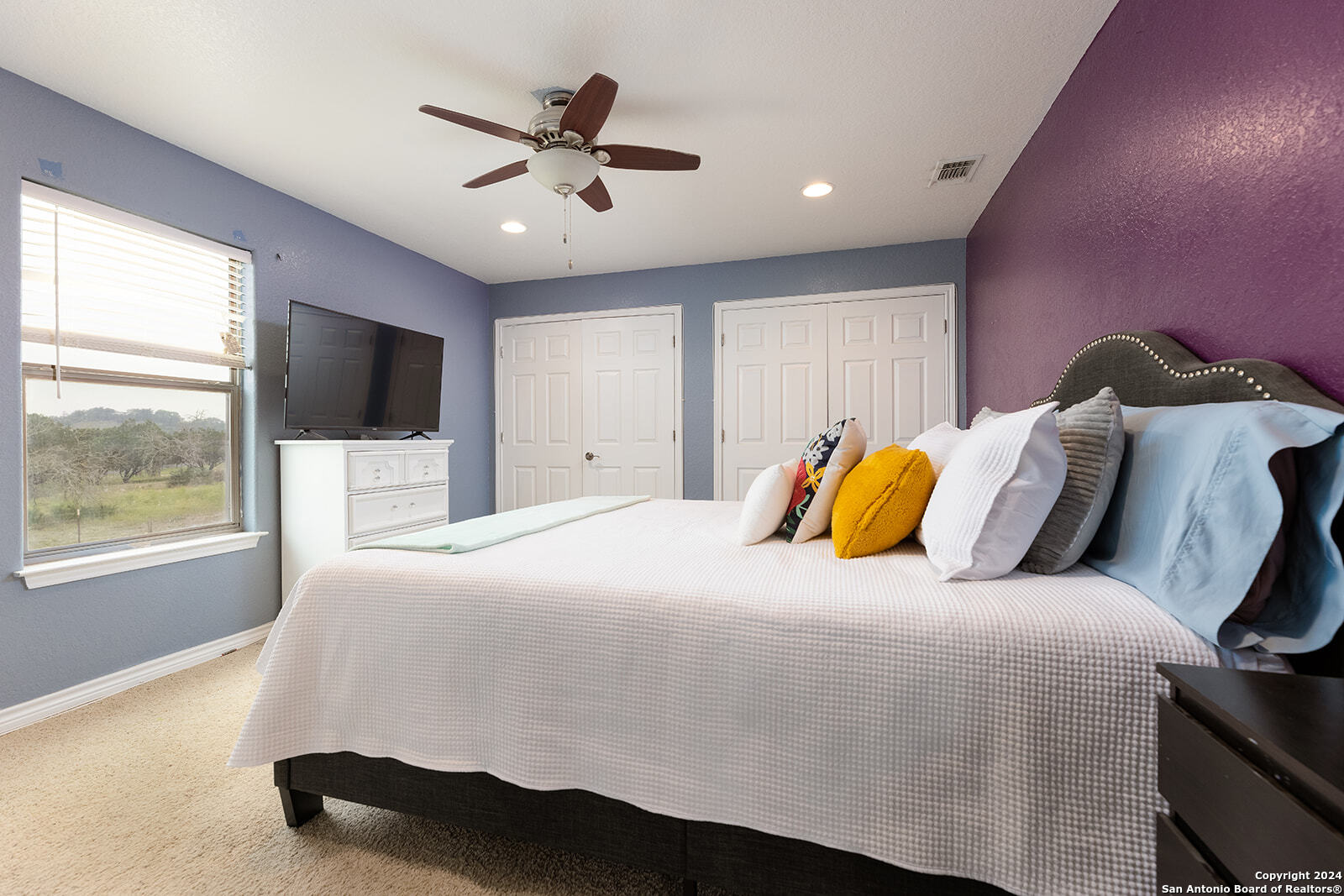 140 Twin Springs Road North Kerrville, TX 78028 - Photo 20 of 47 a bedroom with a bed and a chandelier