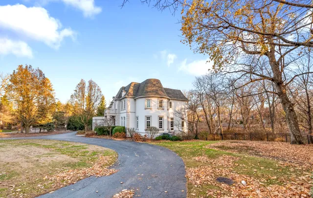 a front view of a house with a yard covered with snow