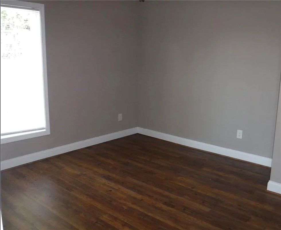 308 South Poplar Street Seneca, SC 29678 - Photo 3 of 9 This spacious room features rich wood flooring, ideal for a flexible living space.