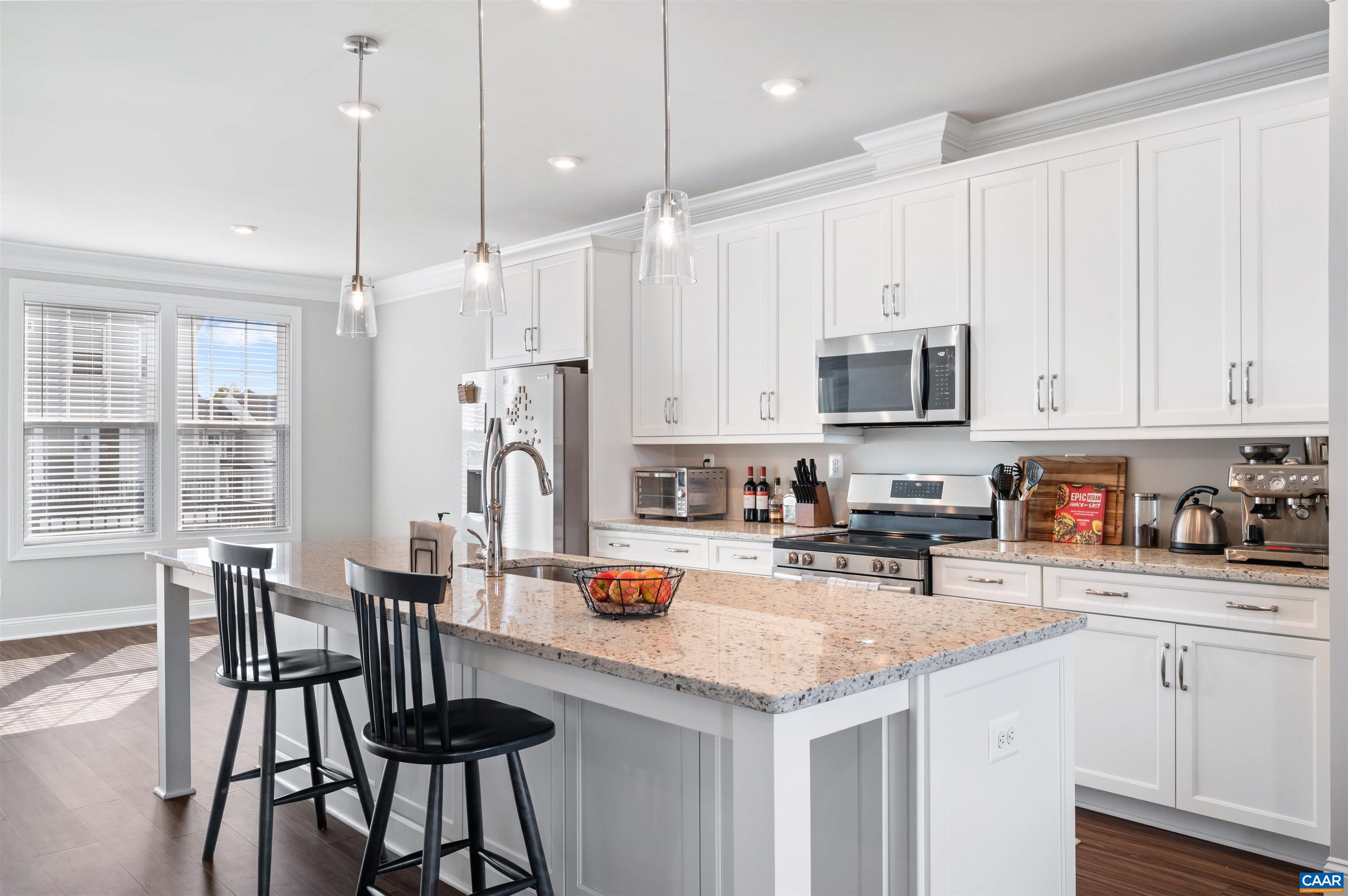 785 Park Ridge Drive Crozet, VA 22932 - Photo 14 of 50 a kitchen with stainless steel appliances granite countertop a stove top oven a refrigerator a sink a dining table and chairs with white cabinets