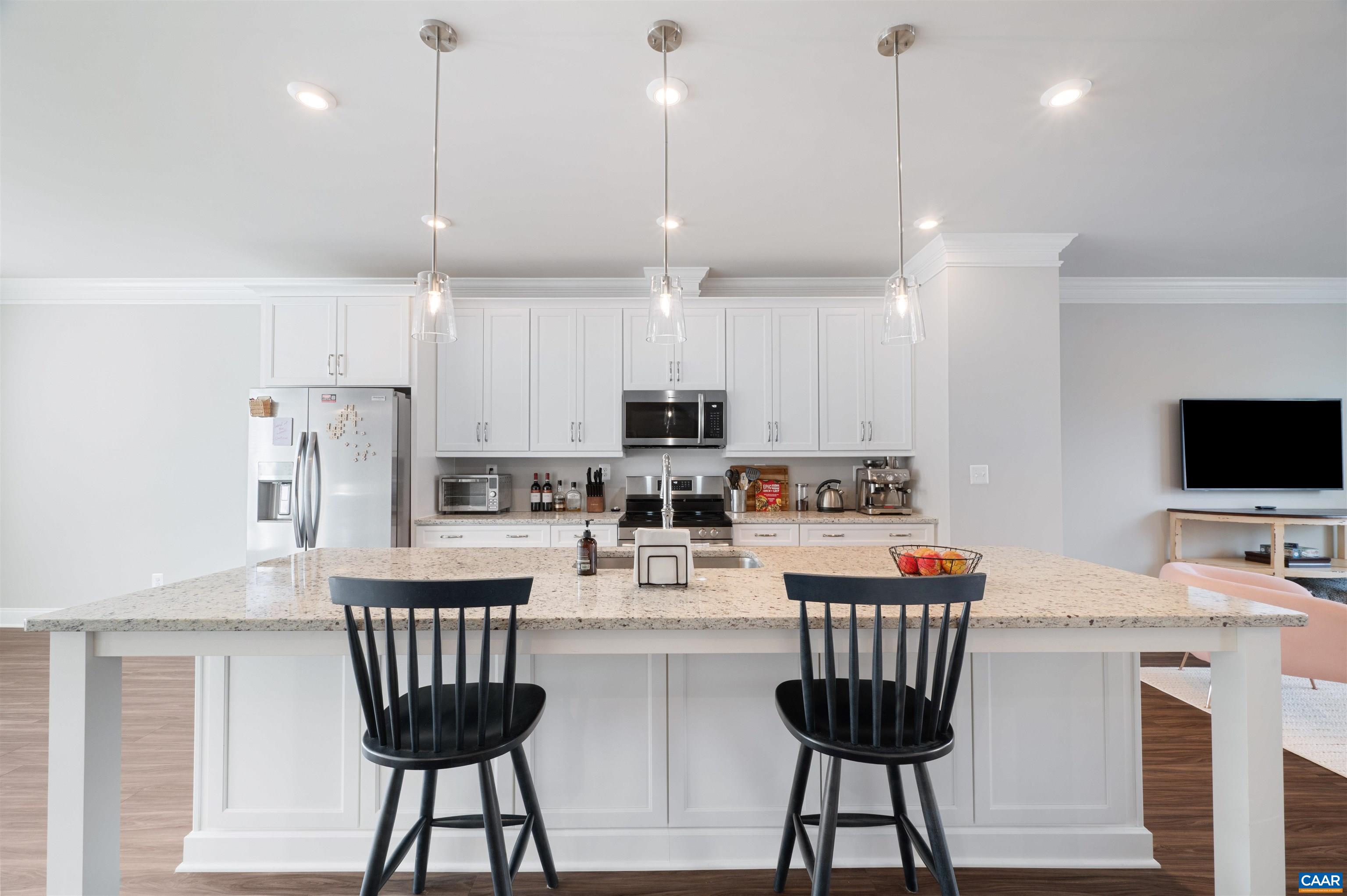 785 Park Ridge Drive Crozet, VA 22932 - Photo 15 of 50 a kitchen with stainless steel appliances kitchen island granite countertop a dining table chairs refrigerator and microwave