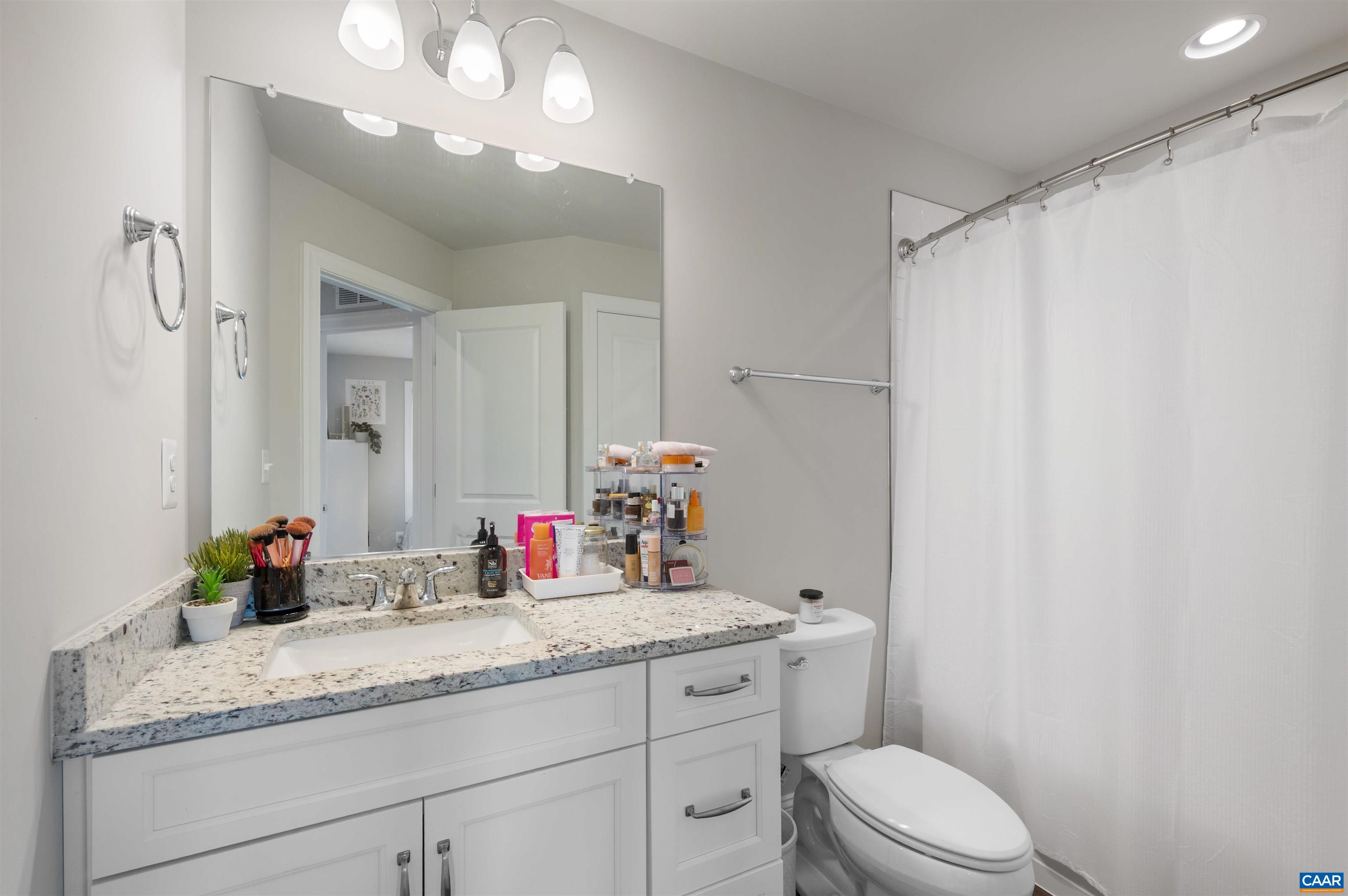 785 Park Ridge Drive Crozet, VA 22932 - Photo 33 of 50 a bathroom with a granite countertop sink a toilet and a mirror