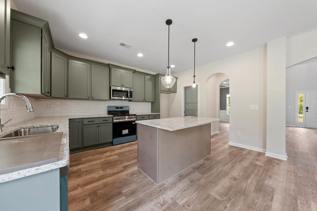 575 Bohannon Road Grantville, GA 30220 - Photo 11 of 33 a kitchen with stainless steel appliances granite countertop a sink a stove and a refrigerator