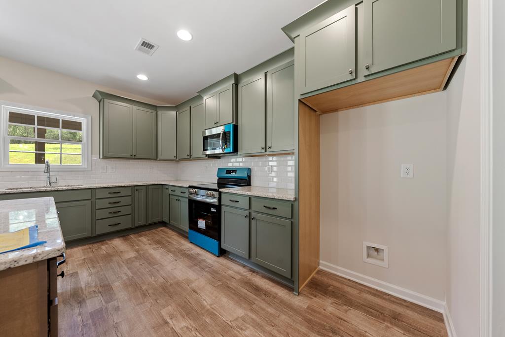 575 Bohannon Road Grantville, GA 30220 - Photo 9 of 33 a kitchen with a refrigerator and a stove top oven
