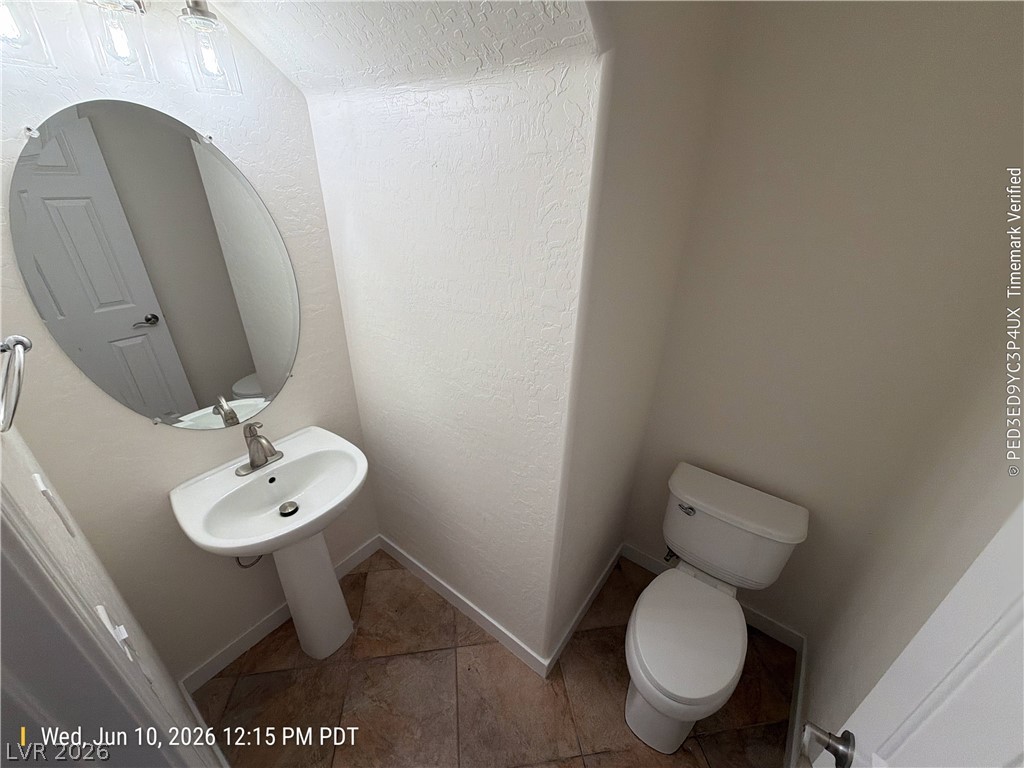 2388 Rue Bienville Way Henderson, NV 89044 - Photo 7 of 16 A well-appointed powder room features a classic pedestal sink and tiled flooring.