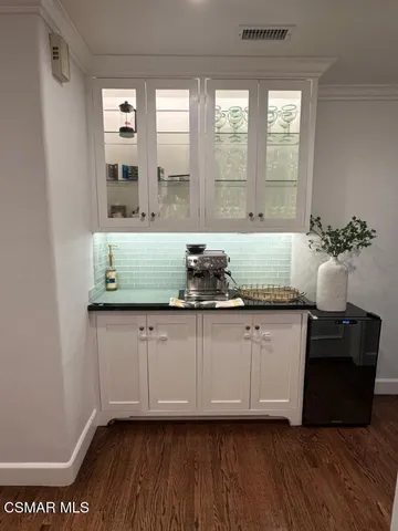 a view of kitchen with granite countertop a sink and a white wooden cabinets