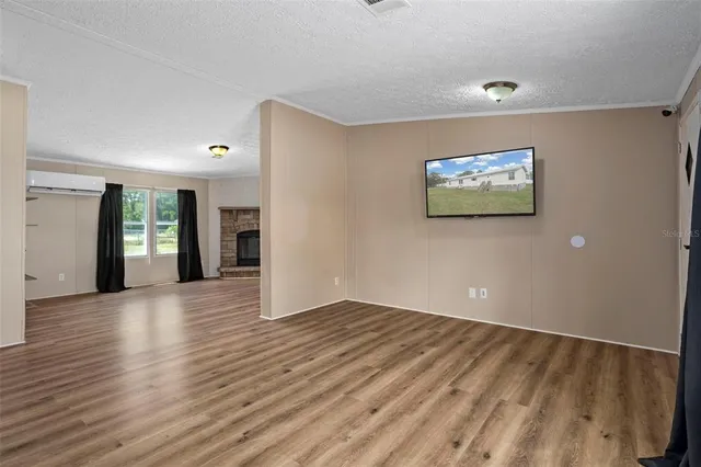 a view of empty room with wooden floor and fireplace