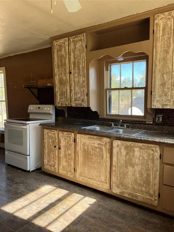 a kitchen with a stove and white cabinets