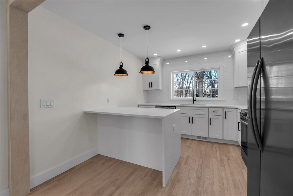 4 Hancock Street Shrewsbury, MA 01545 - Photo 12 of 33 a kitchen with white cabinets and stainless steel appliances