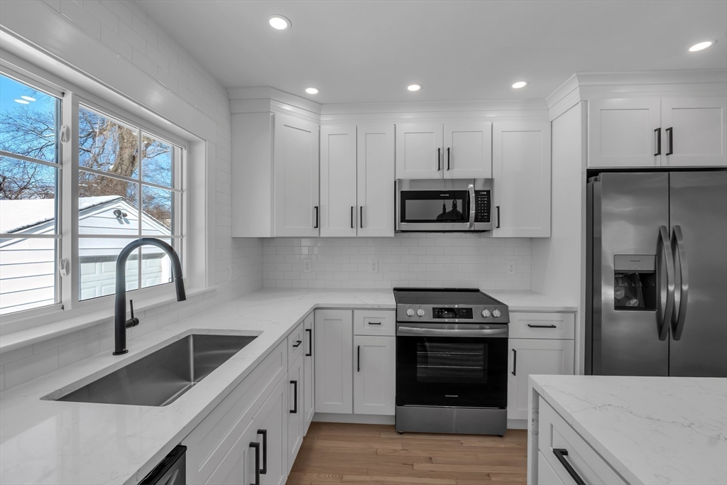4 Hancock Street Shrewsbury, MA 01545 - Photo 14 of 33 a kitchen with white cabinets and stainless steel appliances