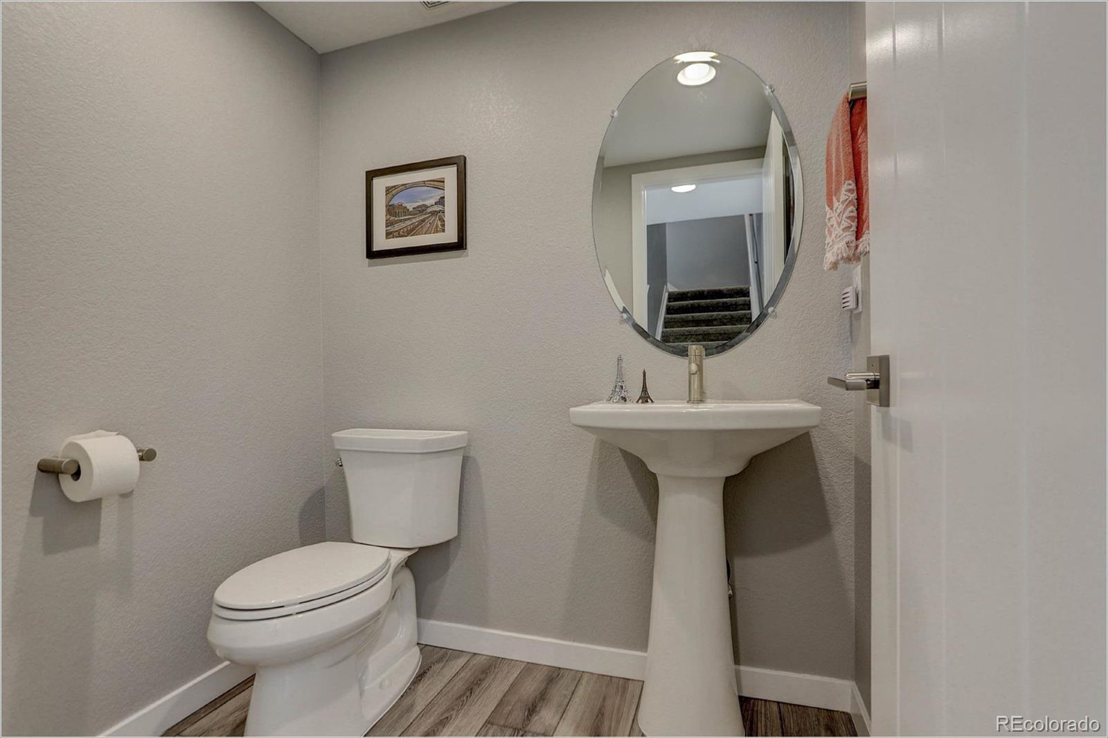 8928 Delacorte Street Highlands Ranch, CO 80129 - Photo 19 of 26 a bathroom with a toilet a sink and mirror