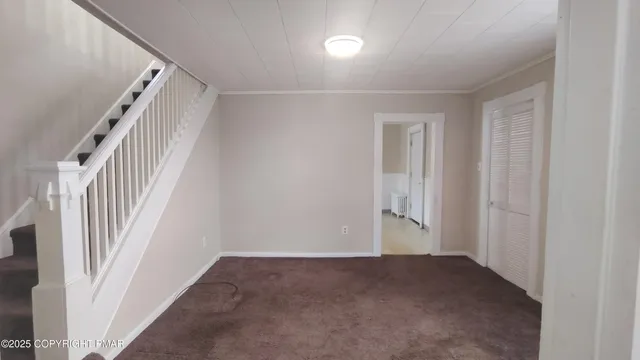 an empty room with staircase and white walls