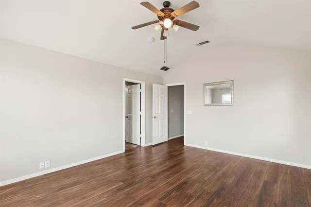 a view of a room with wooden floor and a ceiling fan
