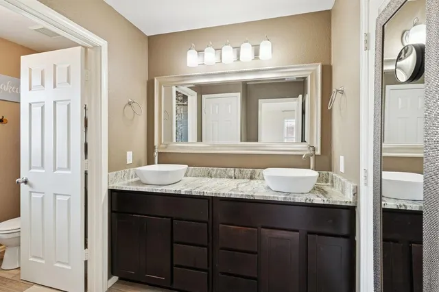 a bathroom with a granite countertop sink and a mirror