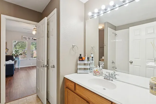 a bathroom with a sink vanity granite tub and shower