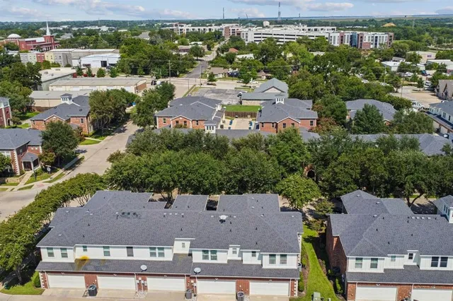 an aerial view of multiple houses with a yard