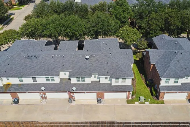 an aerial view of residential houses with outdoor space and parking