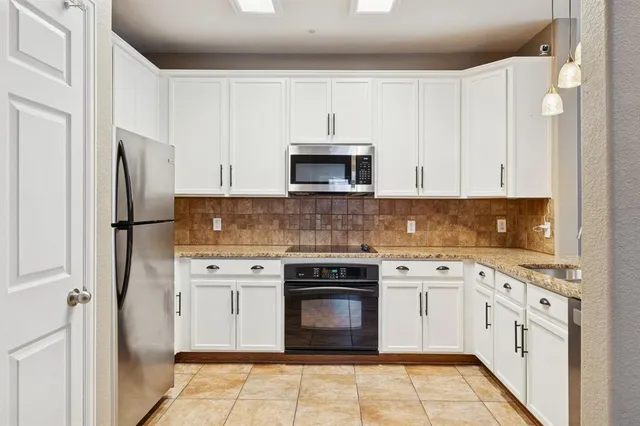 a kitchen with cabinets stainless steel appliances and sink