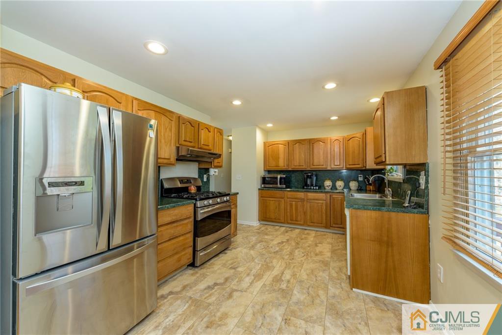 12 Thompson Bridge Road Jackson, NJ 08527 - Photo 8 of 25 a kitchen with stainless steel appliances granite countertop a refrigerator and a stove top oven