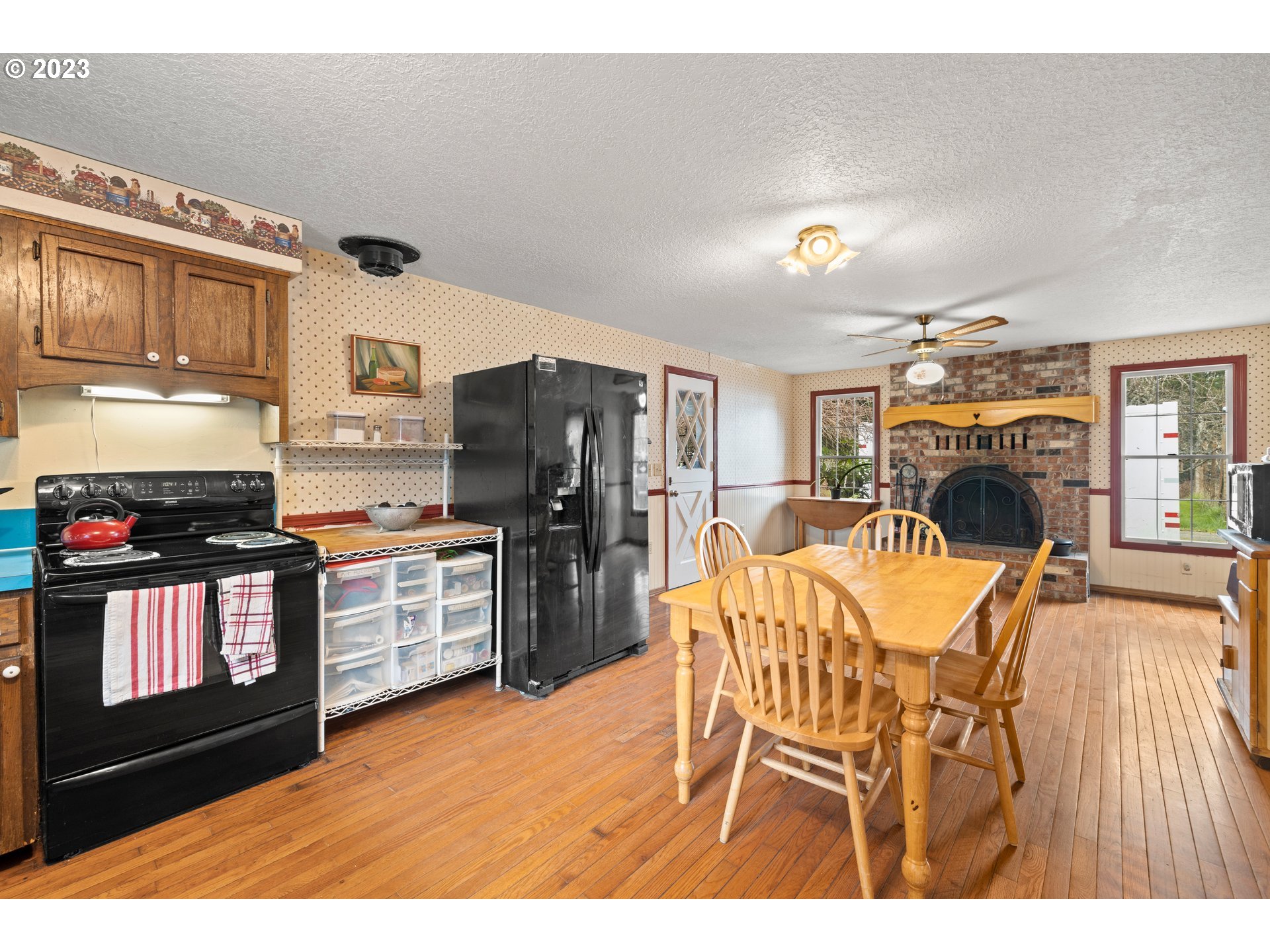 23231 South Engstrom Road Colton, OR 97017 - Photo 20 of 30 a open kitchen with stainless steel appliances kitchen island granite countertop a refrigerator a stove top oven and a sink with wooden floor