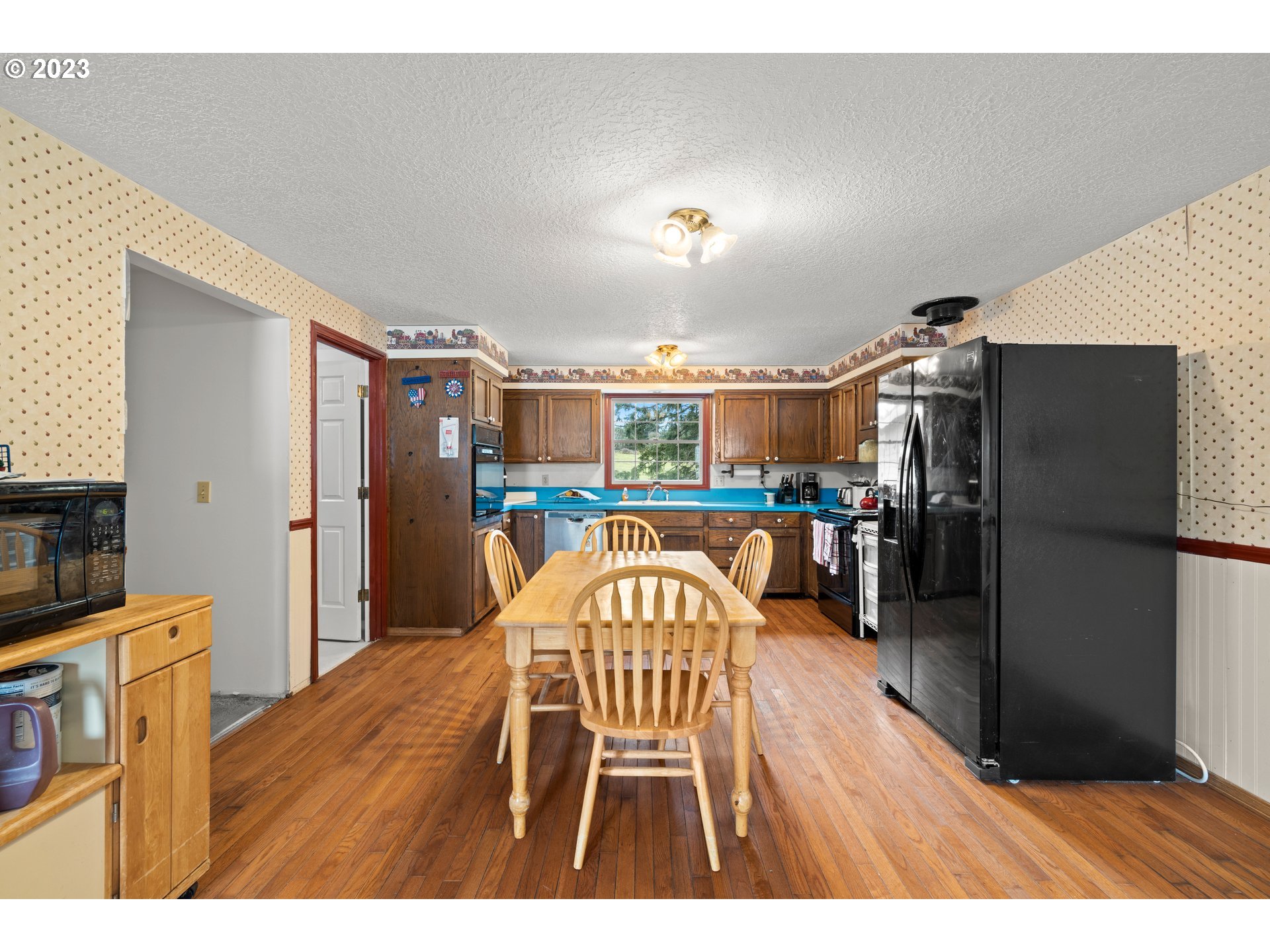 23231 South Engstrom Road Colton, OR 97017 - Photo 28 of 30 a open kitchen with stainless steel appliances granite countertop a refrigerator a stove a sink dishwasher and a dining table with wooden floor