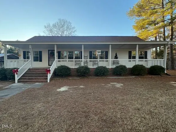 a front view of a house with a yard and potted plants