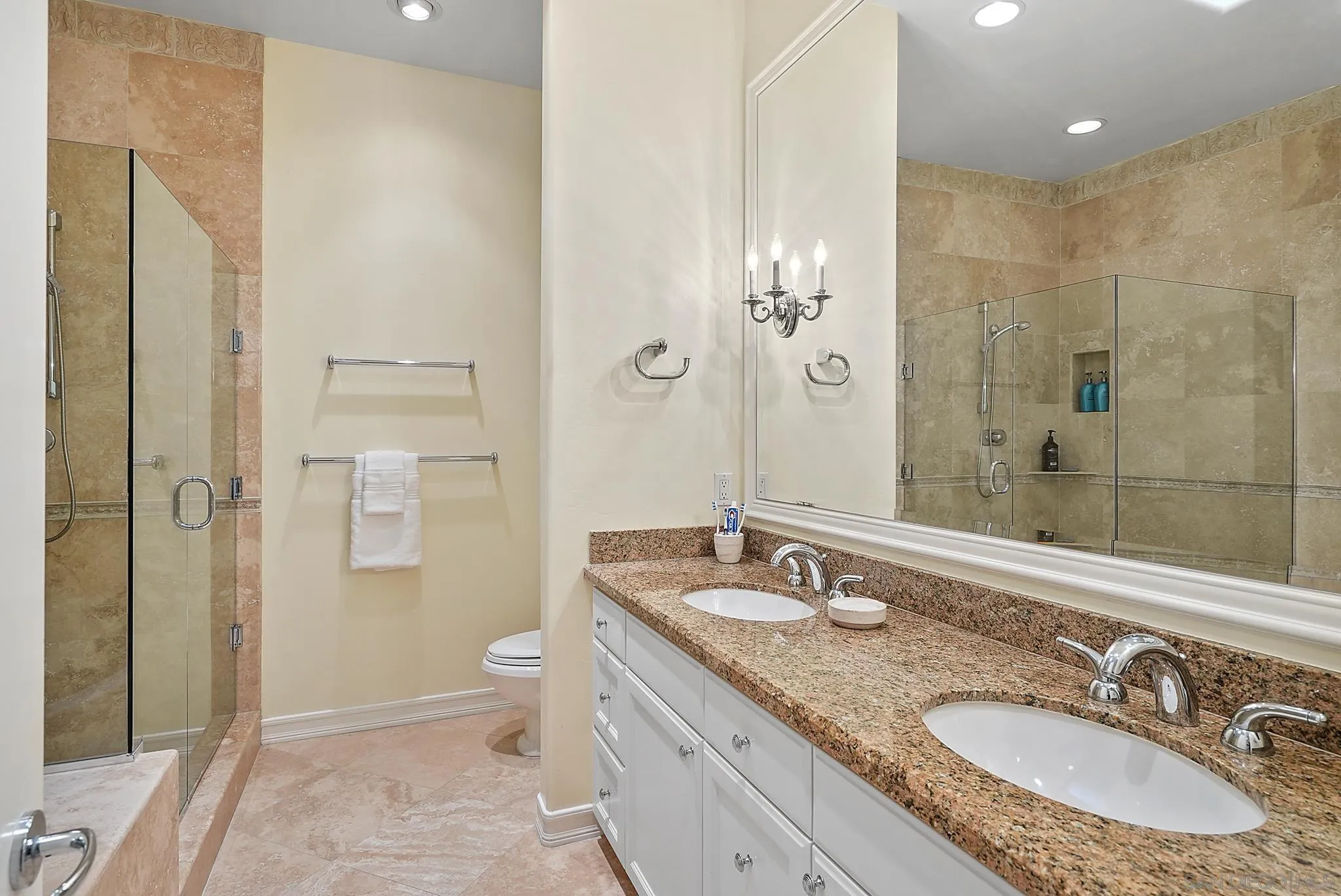 7836 Ivanhoe Avenue La Jolla, CA 92037 - Photo 21 of 31 a bathroom with a granite countertop double vanity sink a mirror and a shower